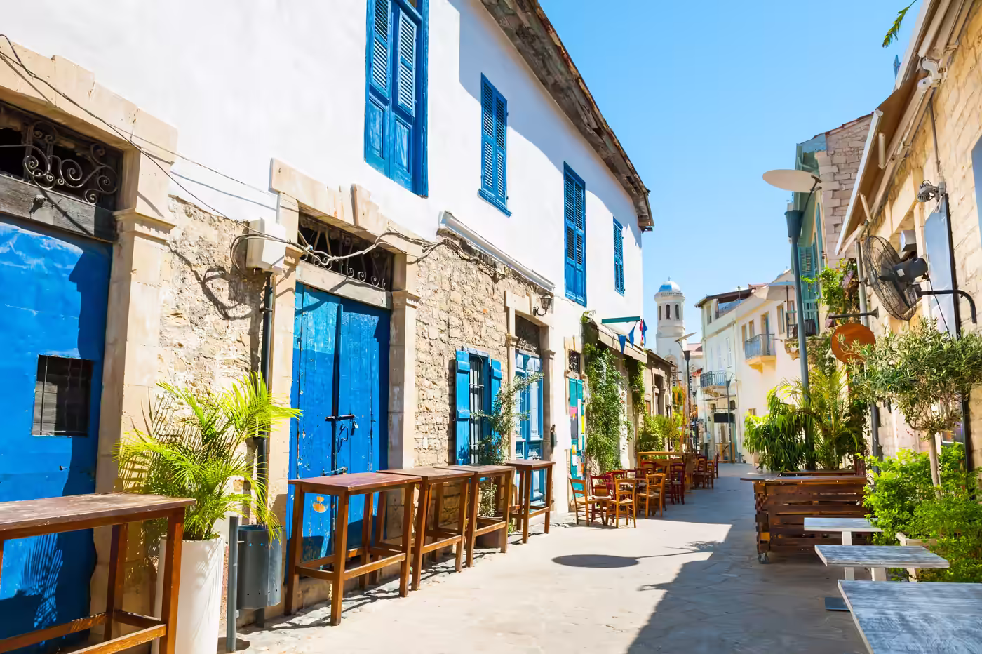 Wohnung auf Zypern kaufen – Leben in charmanten Altstadtvierteln Mediterrane Altstadtgasse mit Cafés und traditionellen Häusern auf Zypern – beliebte Wohnlage für Apartments